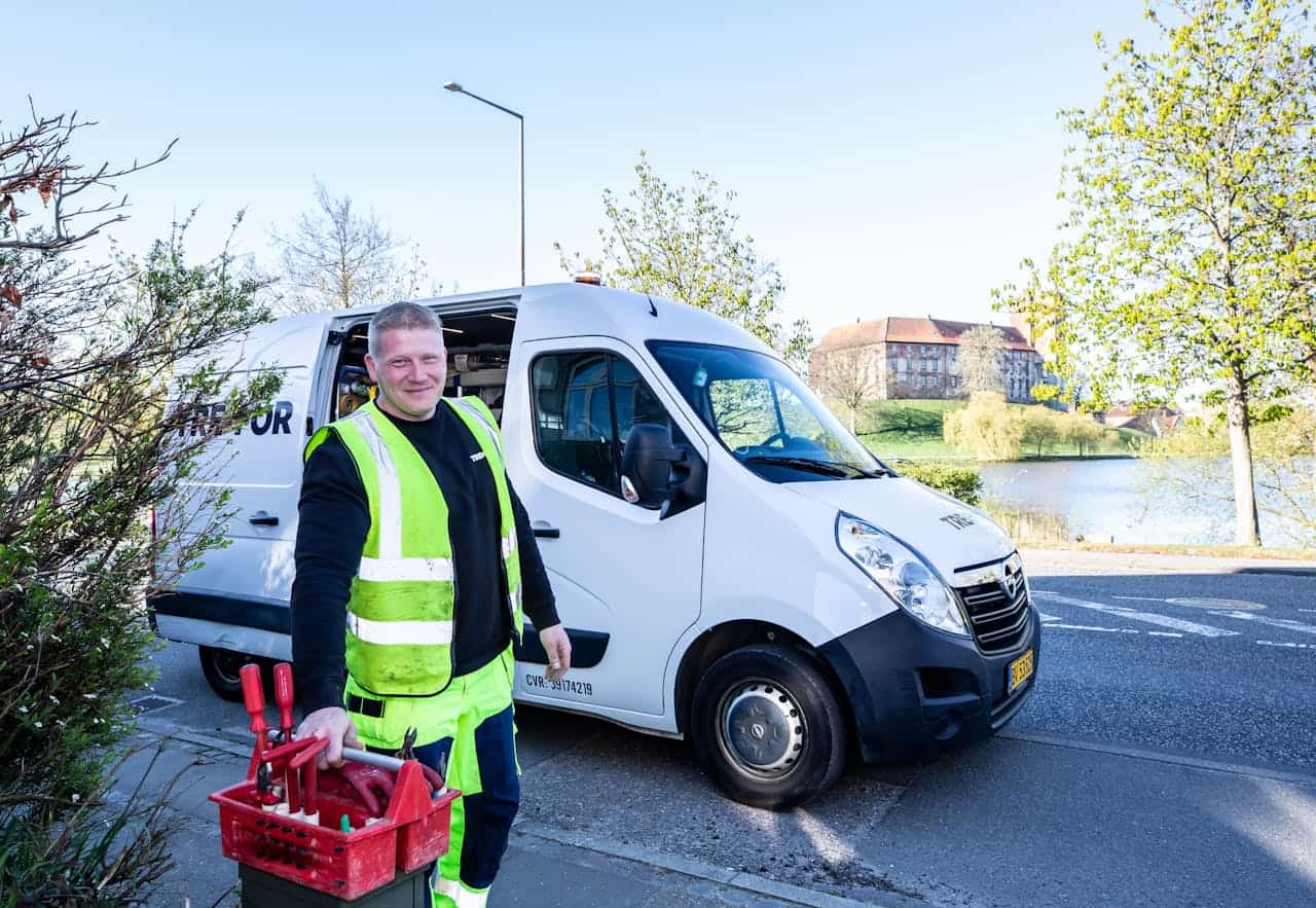Local service technician standing next to service van with tools ready for repair work